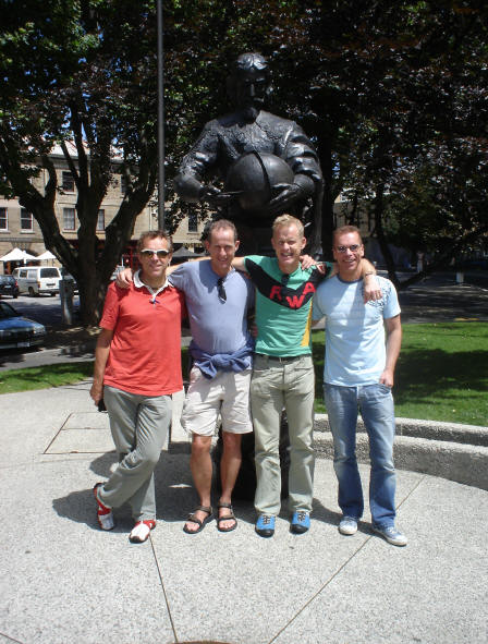 De vier reisgenoten op een plein van Hobart bij het monument voor Abel Tasman.