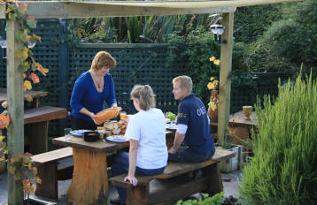 Janine serveert lunch in ded tuin.