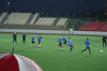 In de stromende regen werkt Oranje (in het blauw) een training af als voorbereiding op de interland later in de week.